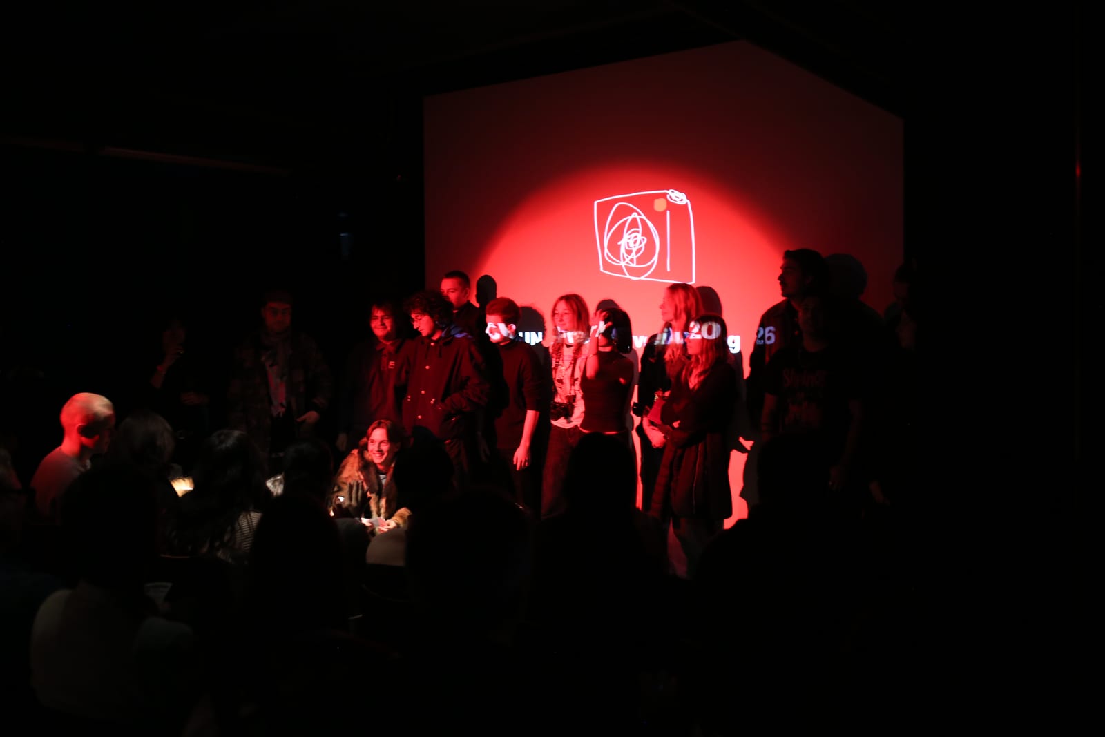 Uncut Award 2026: a group on stage in red light in front of the festival logo, the audience in the foreground.